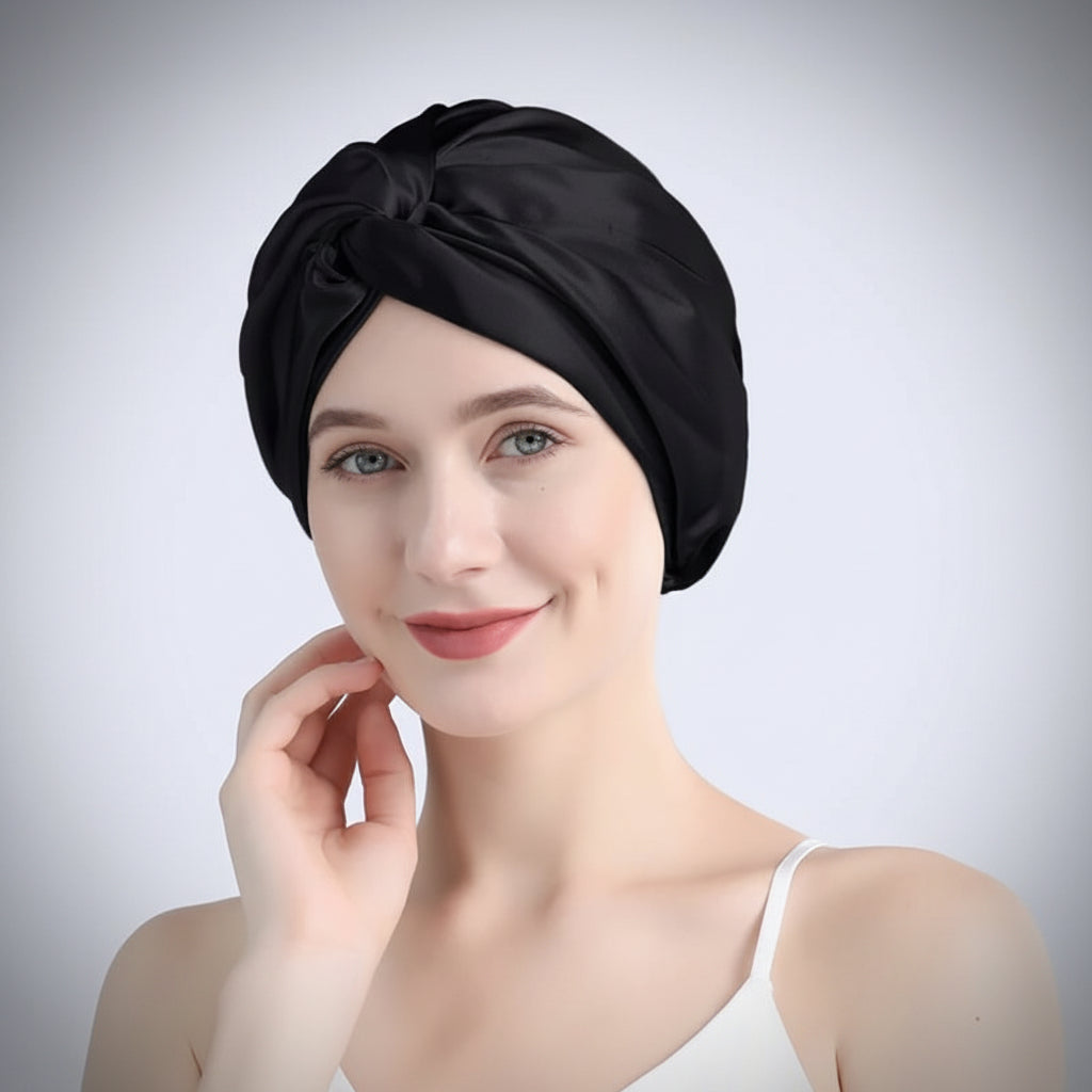 Woman wearing a black satin headscarf on a light gray background